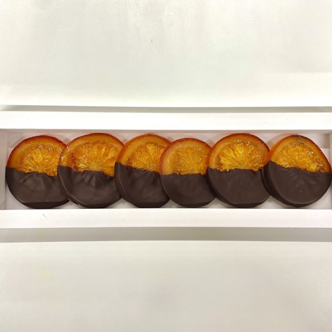 Tranches d’oranges confites  enrobées partiellement de chocolat d’origine noir 70%